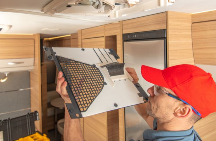 A technician is fixing equipment in an RV, emphasizing a commercial appliance repair service operating in Houston, TX.